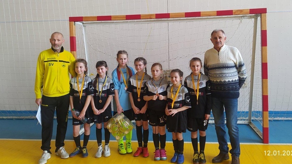 Юні червоноградські футболістки із головою Асоціації футболу Червоноградського району Богданом Ляховським (крайній справа) та тренером Сергієм Васьком. 